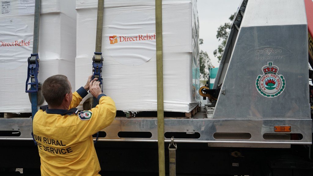 Firefighter Kurt Hill of Albion Park Rural Fire Service loads 15,000 masks on Jan. 16, 2020, in Picton, New South Wales, Australia. The masks would go to fire crews and community members still enduring poor air quality. (Lara Cooper/Direct Relief)
