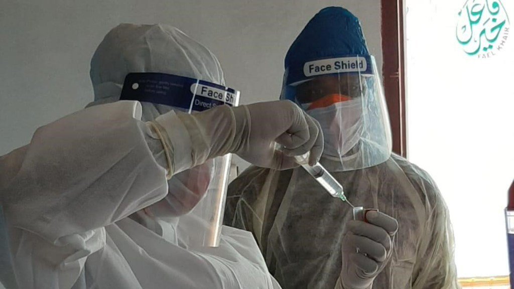 Health workers prepare a dose of medication. (Photo courtesy of HOPE for Bangladesh)
