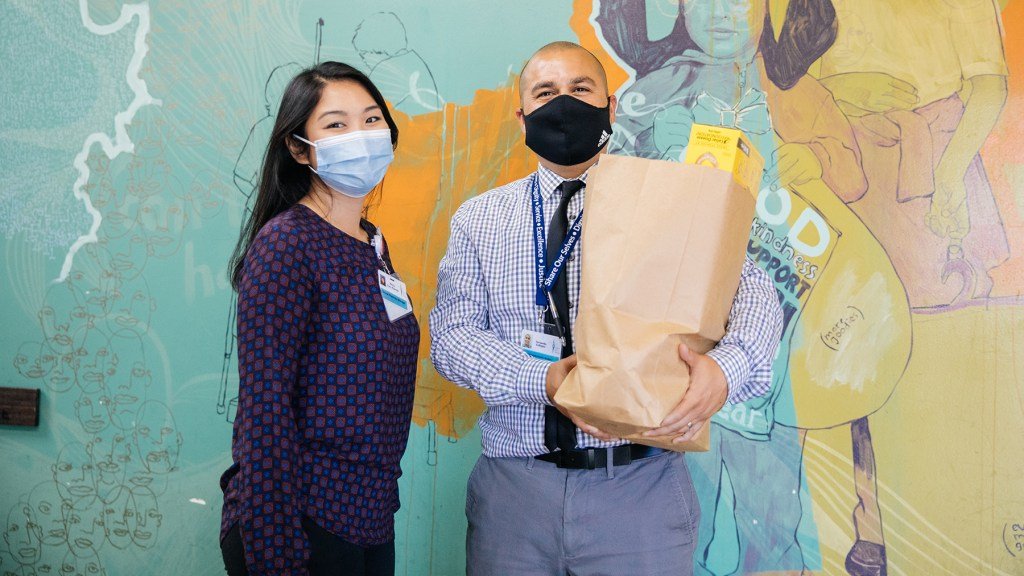 Nancy Dao, clinical pharmacy manager and Fernando Gallegos, Community Health Work and Pharmacy Tech. in the Food Pantry at Sharing Our Selves (SOS) in Costa Mesa, CA. where donated food is repackaged and served to those in need. As a BD Helping Build Health Communities Award Winner, Share Our Selves (SOS) has strengthened their Clinical Pharmacy program specifically to treat chronic disease such as diabetes and hypertension more effectively. They’ve used the grant funds implemented by Direct Relief to hire a Commmunity Health Worker and Pharmacy Tech (Fernando Gallegos) to make home visits, deliver medicine, assess social determinants of health, and further develop Telehealth effectiveness and digital literacy. SOS is a nationally recognized health center providing high quality, comprehensive safety net services to the Orange County community. One of 256 health centers nationally to be designated as a Healthcare for the Homeless provider, SOS is a patient-centered medical home and values the concept of the right person, the right treatment, at the right time. PHOTO: Donnie Lloyd Hedden Jr. 2021